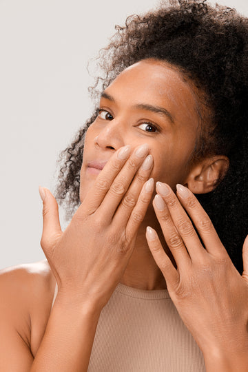 Woman applying Dr. Few Skincare Tinted Mineral Sunscreen onto face
