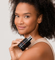 Woman holding Dr. Few Skincare Rejuvenating Eye + SPF 15