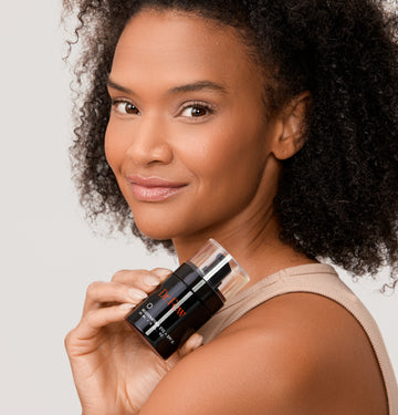 Woman holding Dr. Few Skincare Rejuvenating Eye + SPF 15