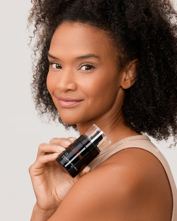 Woman holding Dr. Few Skincare Rejuvenating Eye + SPF 15
