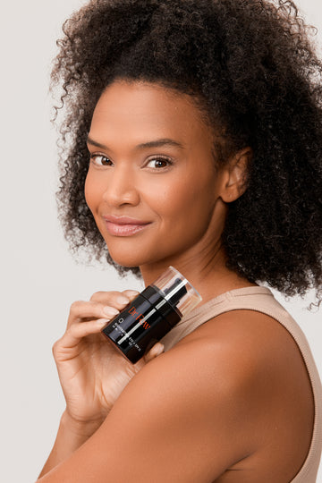 Woman holding Dr. Few Skincare Rejuvenating Eye + SPF 15