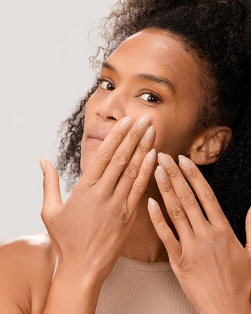 Woman applying Dr. Few Skincare Tinted Mineral Sunscreen onto face